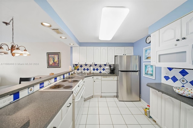 kitchen featuring pendant lighting, white appliances, white cabinets, sink, and a chandelier