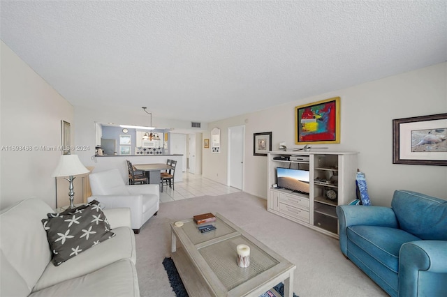 living room featuring light carpet and a textured ceiling