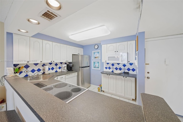 kitchen featuring white appliances, sink, white cabinetry, and backsplash