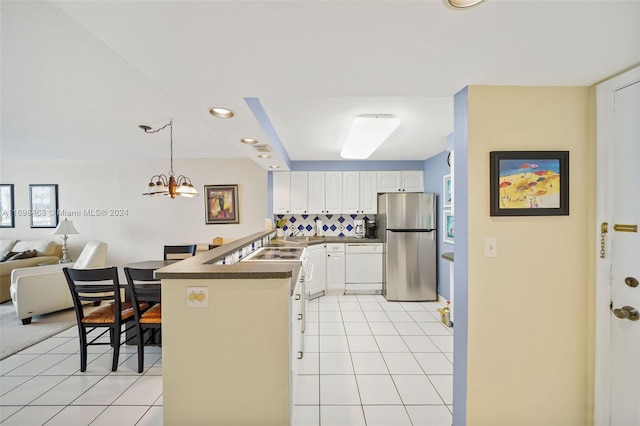 kitchen featuring kitchen peninsula, stainless steel fridge, dishwasher, white cabinetry, and hanging light fixtures