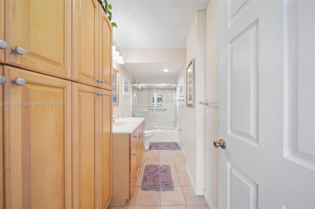 full bathroom with combined bath / shower with glass door, tile patterned floors, a textured ceiling, vanity, and toilet