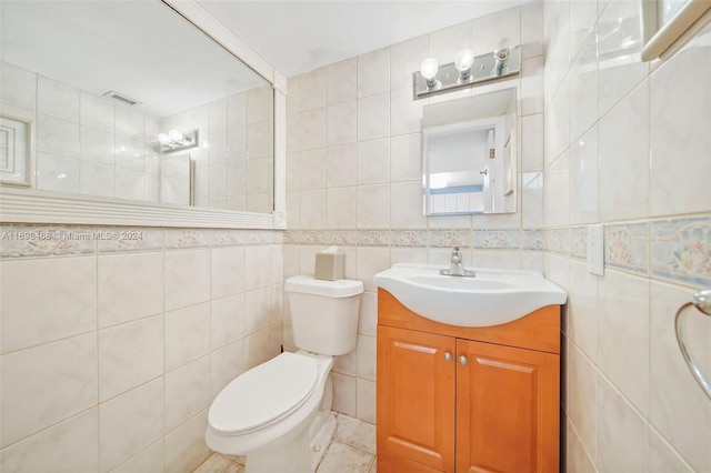 bathroom featuring tile patterned floors, vanity, tile walls, and toilet