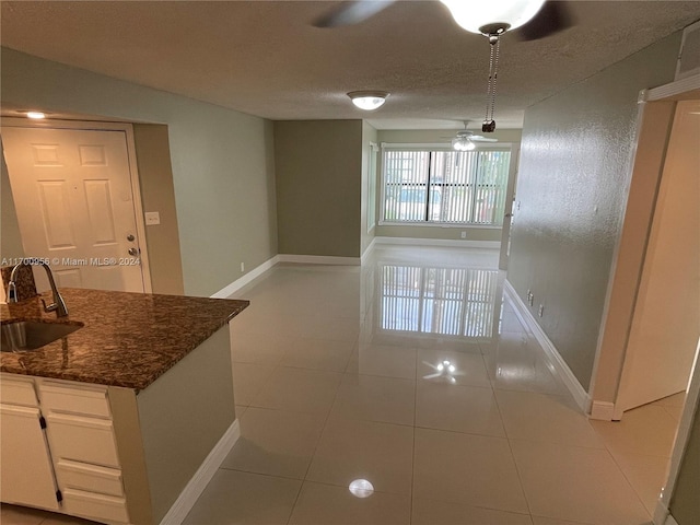 unfurnished dining area with light tile patterned floors, a textured ceiling, and sink