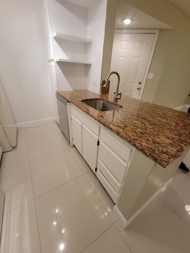 kitchen featuring dark stone countertops, sink, white cabinets, and stainless steel dishwasher