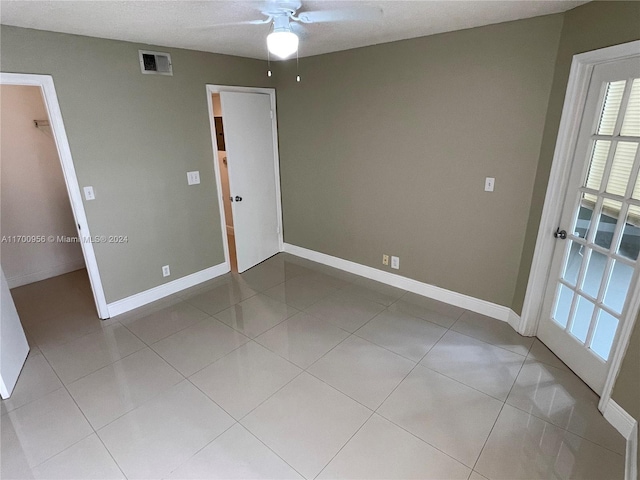 spare room featuring ceiling fan and light tile patterned floors