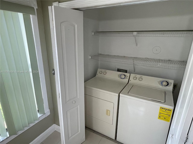 laundry room featuring washer and clothes dryer and light tile patterned floors