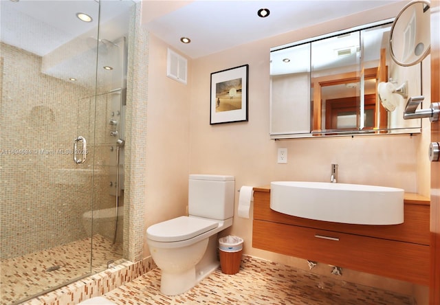 bathroom with tile patterned flooring, toilet, vanity, and a shower with shower door