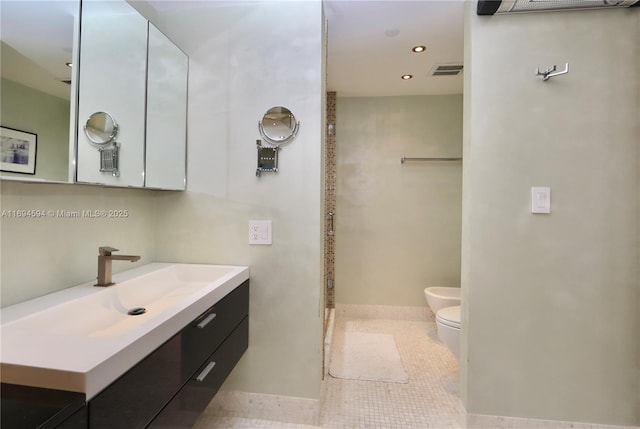 bathroom with a bidet, vanity, toilet, and tile patterned flooring