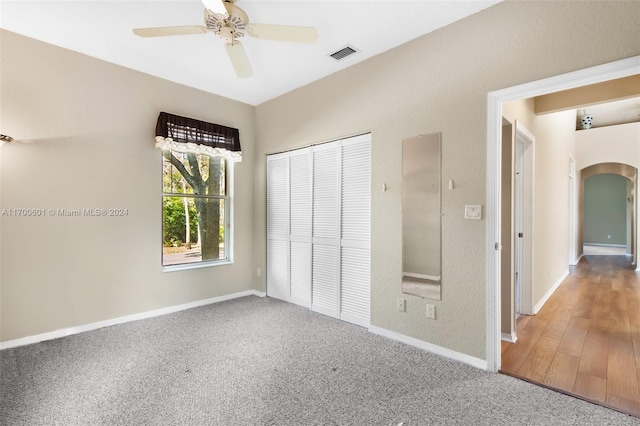 unfurnished bedroom with ceiling fan, a closet, and hardwood / wood-style floors