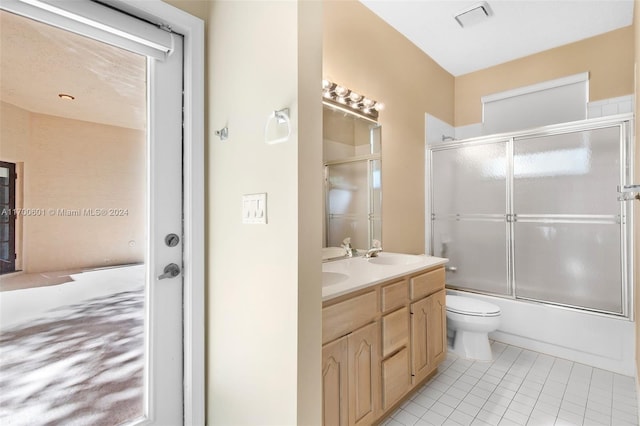 full bathroom with tile patterned floors, shower / bath combination with glass door, vanity, and toilet