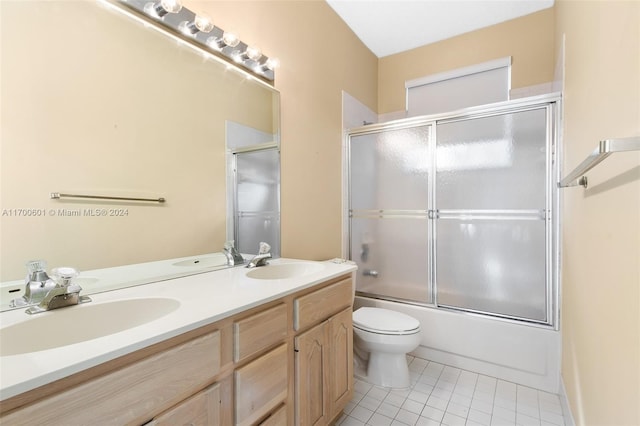 full bathroom featuring tile patterned floors, vanity, toilet, and bath / shower combo with glass door