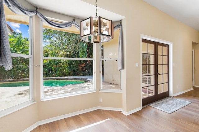 doorway featuring french doors, a notable chandelier, and wood-type flooring