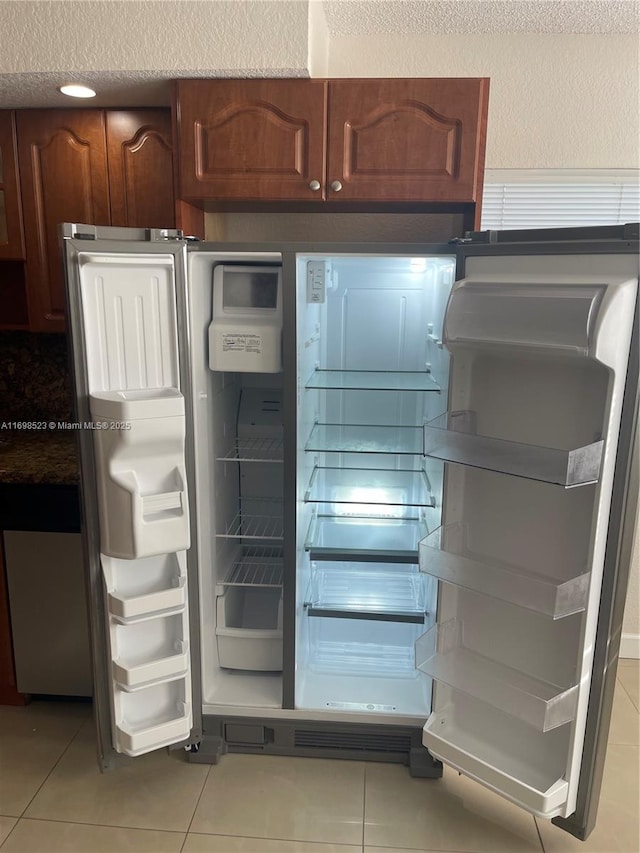 kitchen featuring light tile patterned flooring and refrigerator