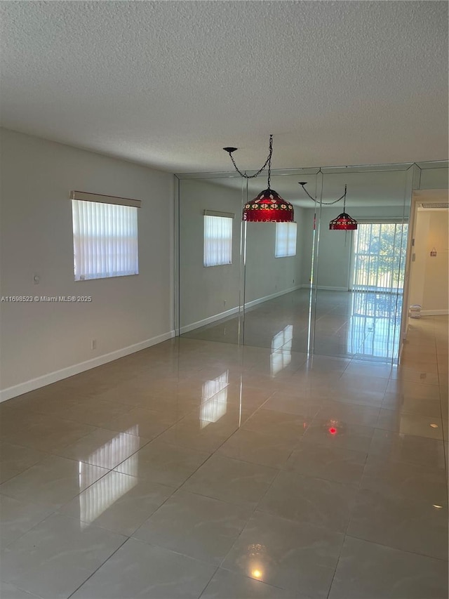 tiled spare room with a textured ceiling