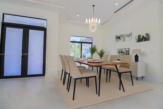 dining room featuring a tray ceiling, french doors, and a chandelier