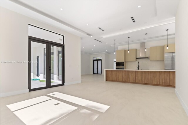 kitchen with french doors, tasteful backsplash, wall chimney exhaust hood, stainless steel appliances, and pendant lighting