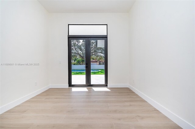 unfurnished bedroom with a barn door, multiple closets, and light hardwood / wood-style floors