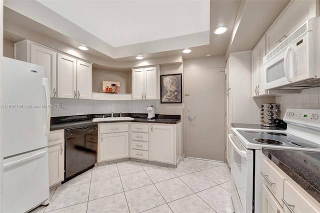 kitchen with white appliances, white cabinets, sink, decorative backsplash, and a tray ceiling