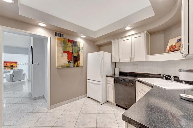 kitchen with a raised ceiling, white cabinets, white refrigerator, and black dishwasher