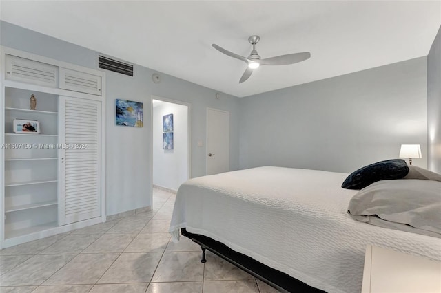 bedroom featuring ceiling fan, a closet, and light tile patterned floors