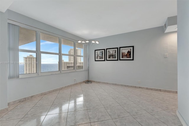 tiled empty room featuring a water view