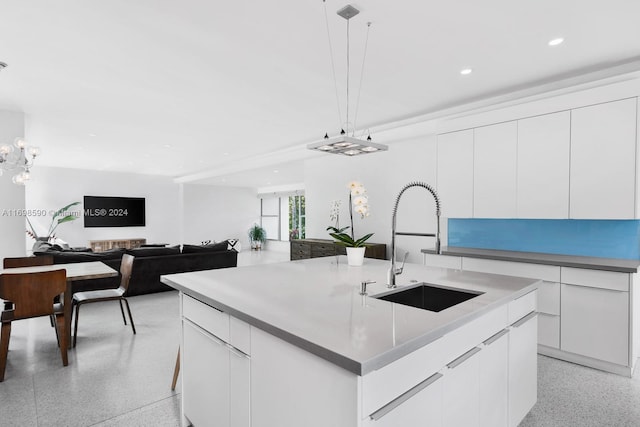 kitchen featuring pendant lighting, white cabinetry, sink, and a spacious island