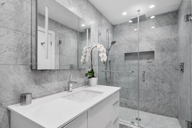 bathroom featuring vanity, an enclosed shower, and tile walls