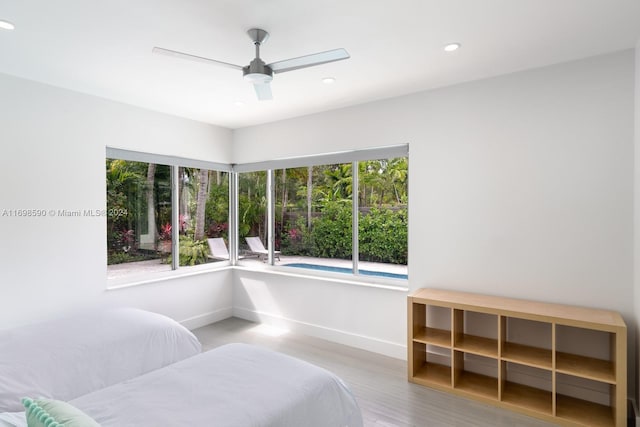 bedroom with wood-type flooring, multiple windows, and ceiling fan