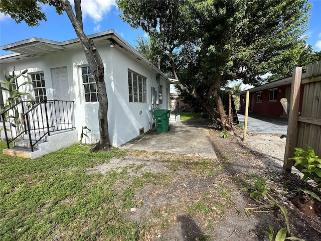 view of side of home featuring a patio area and stucco siding