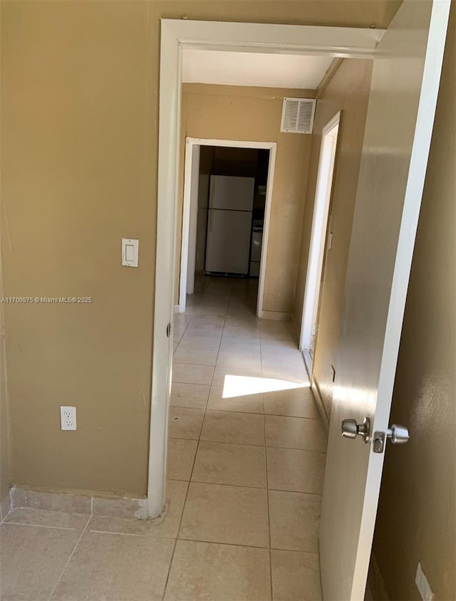 corridor featuring visible vents and light tile patterned floors