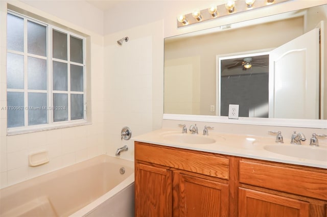 bathroom featuring shower / bathing tub combination, ceiling fan, and vanity