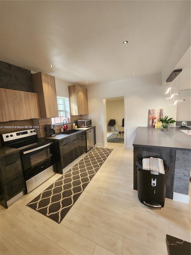13751 NE 1st Ave, Miami, FL 33161 - kitchen featuring appliances with stainless steel finishes, light wood-style floors, recessed lighting, and dark countertops