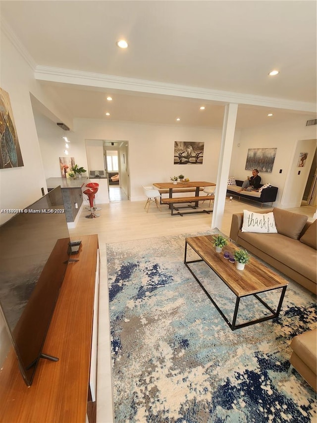 living room with crown molding and hardwood / wood-style flooring