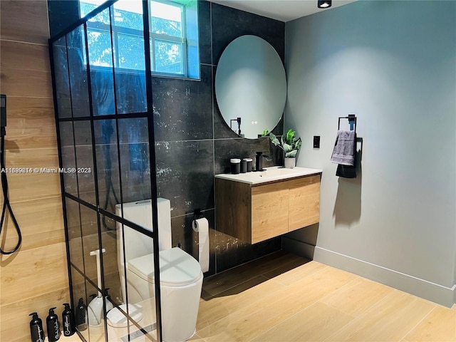 bathroom with vanity, tile walls, and toilet