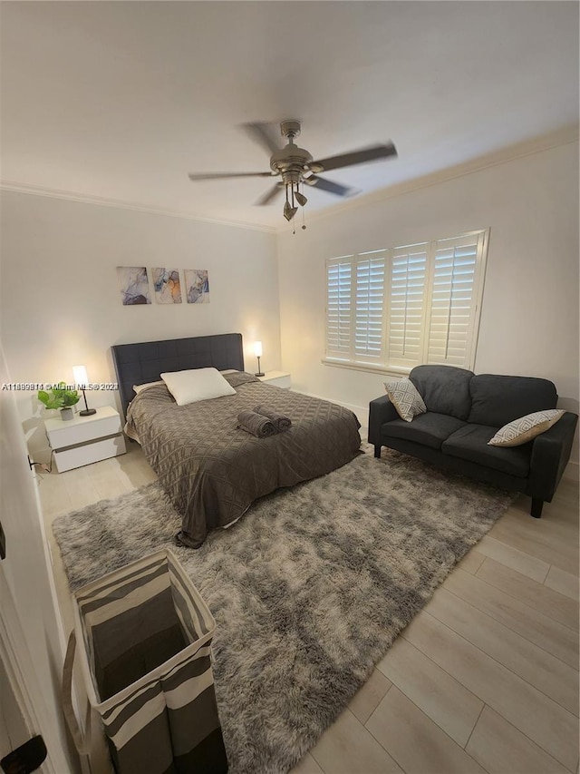 bedroom featuring ceiling fan, crown molding, and light hardwood / wood-style flooring