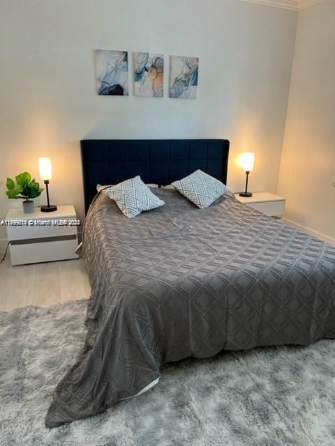 bedroom with hardwood / wood-style flooring and ornamental molding