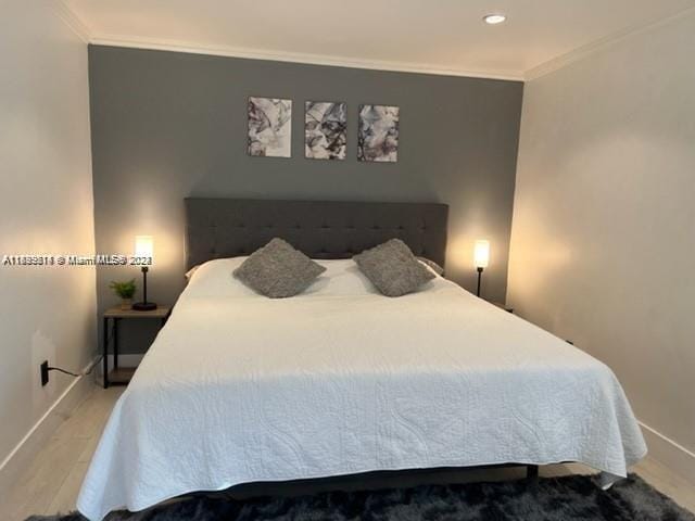 bedroom featuring hardwood / wood-style floors and crown molding