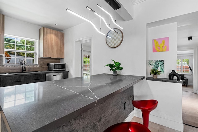13751 NE 1st Ave, Miami, FL 33161 - kitchen featuring modern cabinets, plenty of natural light, dark stone countertops, and appliances with stainless steel finishes