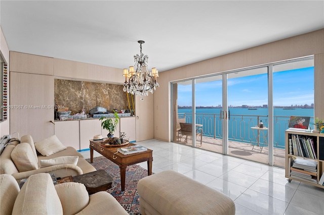 tiled living room featuring a chandelier and a water view