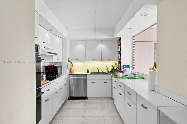 11111 Biscayne Blvd Unit 12F, Miami, FL 33181 - kitchen with black appliances, light countertops, light tile patterned flooring, white cabinetry, and under cabinet range hood