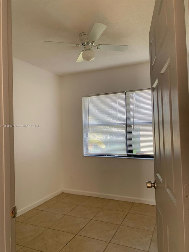 unfurnished room featuring ceiling fan, plenty of natural light, and light tile patterned floors