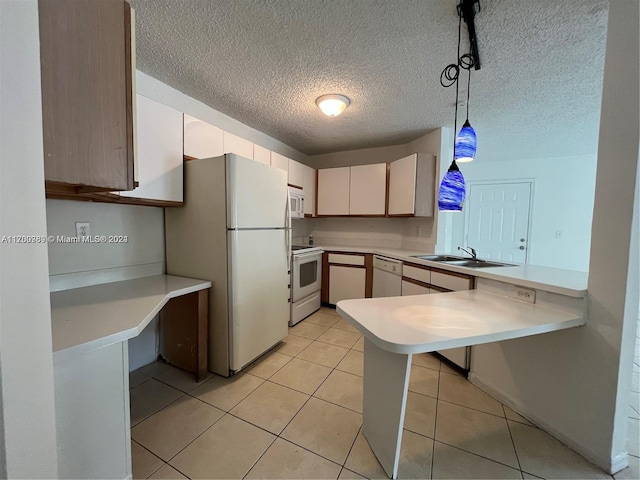 kitchen with sink, pendant lighting, a textured ceiling, white appliances, and light tile patterned flooring