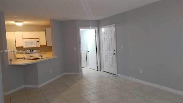 4015 W Mcnab Rd Unit D101, Pompano Beach, FL 33069 - kitchen featuring white microwave, refrigerator, light countertops, stainless steel electric range, and light tile patterned floors