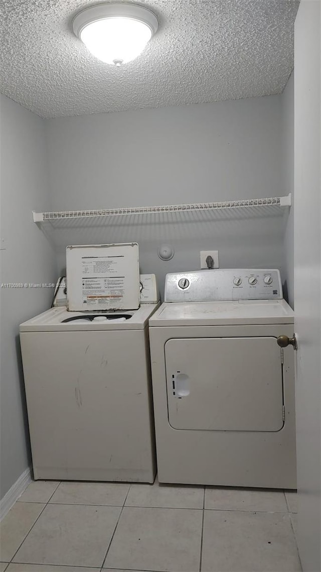 4015 W Mcnab Rd Unit D101, Pompano Beach, FL 33069 - laundry area featuring washer and clothes dryer, a textured ceiling, and light tile patterned floors