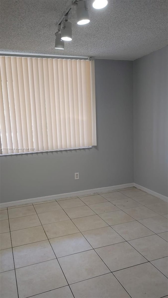 4015 W Mcnab Rd Unit D101, Pompano Beach, FL 33069 - tiled spare room featuring a textured ceiling and baseboards