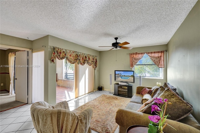 tiled living room with a wealth of natural light, ceiling fan, and a textured ceiling