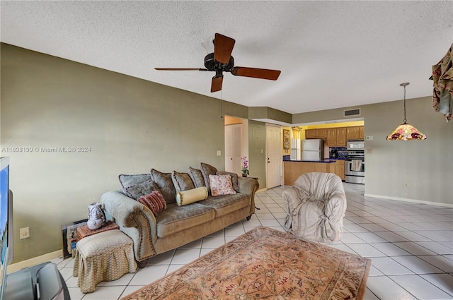 tiled living room featuring a textured ceiling and ceiling fan