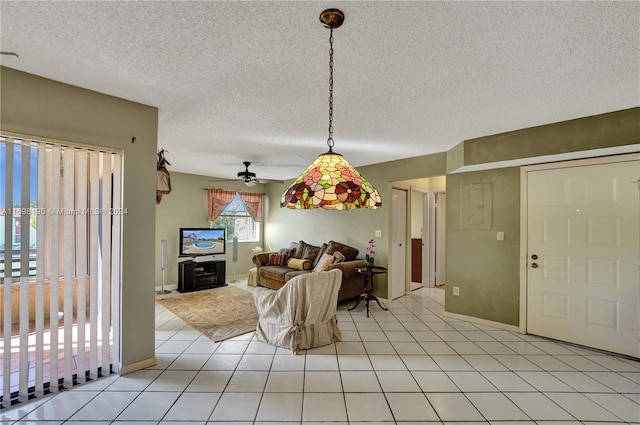 interior space with ceiling fan, light tile patterned floors, and a textured ceiling