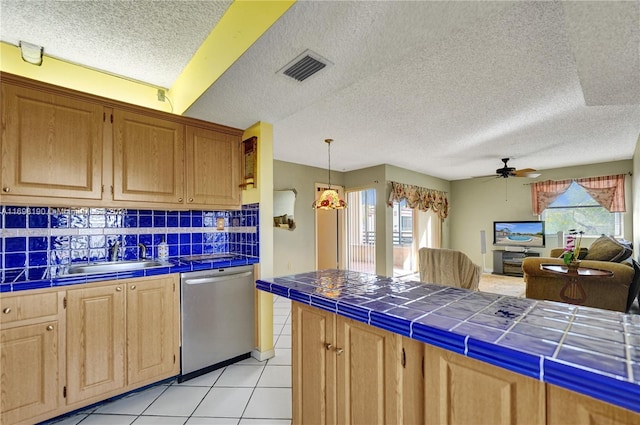 kitchen with dishwasher, plenty of natural light, and tile counters