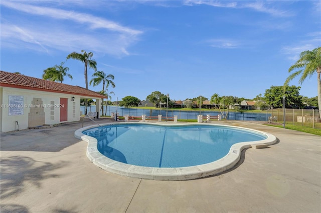 view of pool featuring a patio and a water view